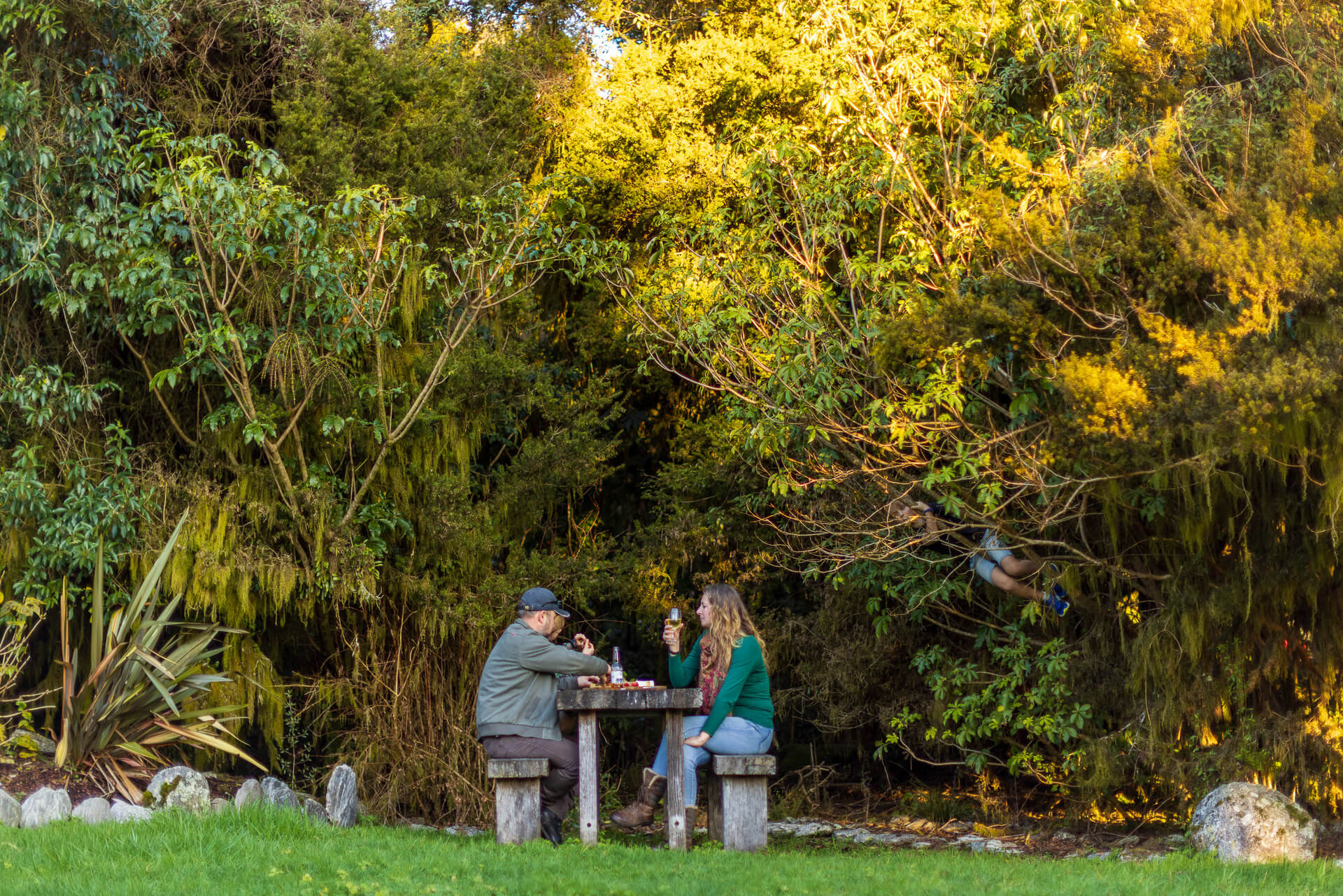 Guests sitting at table enjoying a meal surrounded by trees