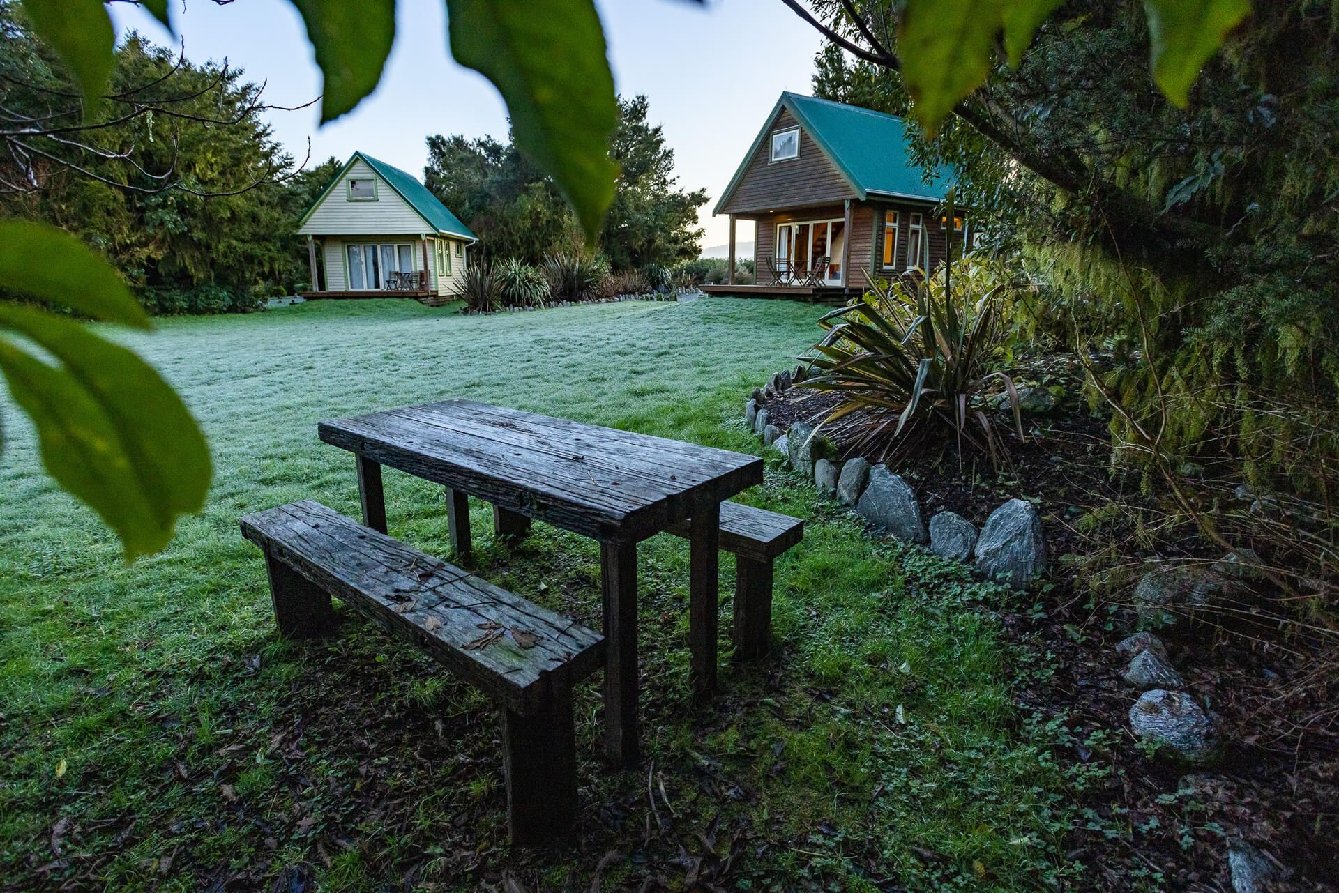 View of wooden table and chairs with frost, Chalets in background